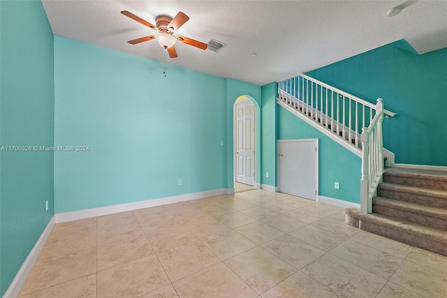 interior space with ceiling fan and a textured ceiling