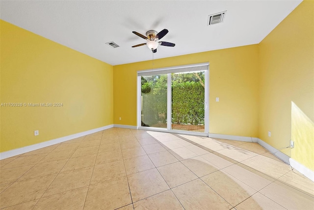 spare room with ceiling fan and light tile patterned flooring