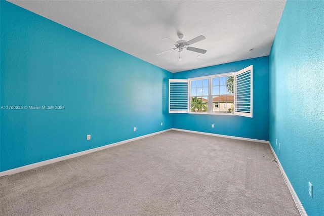 empty room featuring carpet flooring, ceiling fan, and a textured ceiling