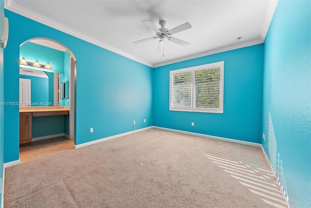 carpeted spare room with ceiling fan and ornamental molding