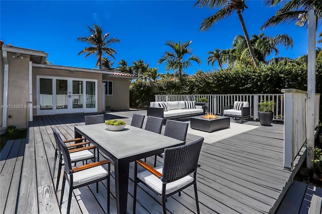 wooden deck featuring an outdoor living space with a fire pit