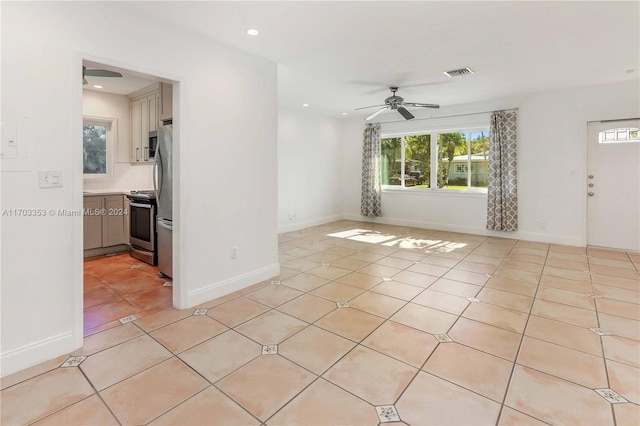 tiled spare room with ceiling fan