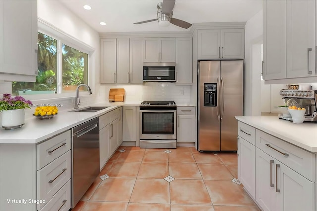 kitchen featuring decorative backsplash, appliances with stainless steel finishes, ceiling fan, sink, and light tile patterned floors