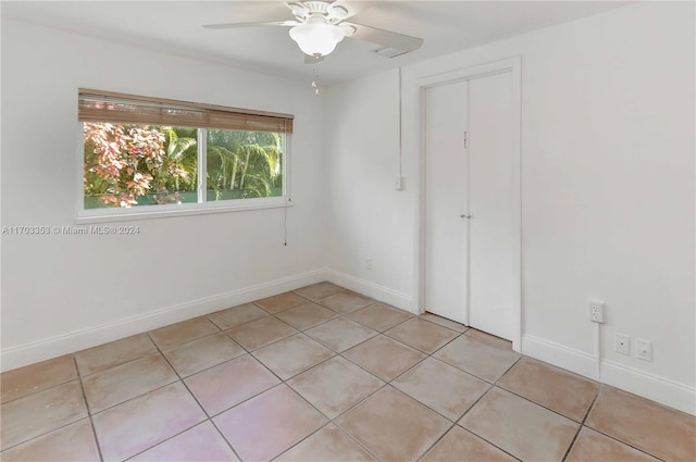 unfurnished bedroom with ceiling fan, a closet, and light tile patterned floors