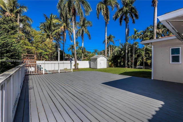 wooden deck featuring a yard and a shed