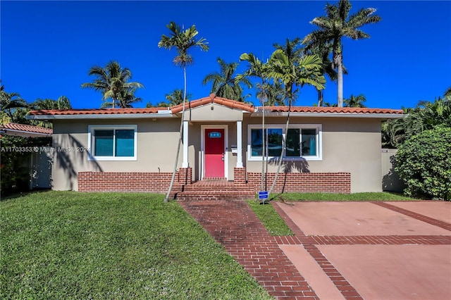 mediterranean / spanish house featuring a front lawn