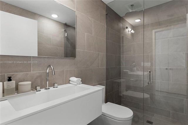 bathroom featuring backsplash, walk in shower, vanity, tile walls, and toilet