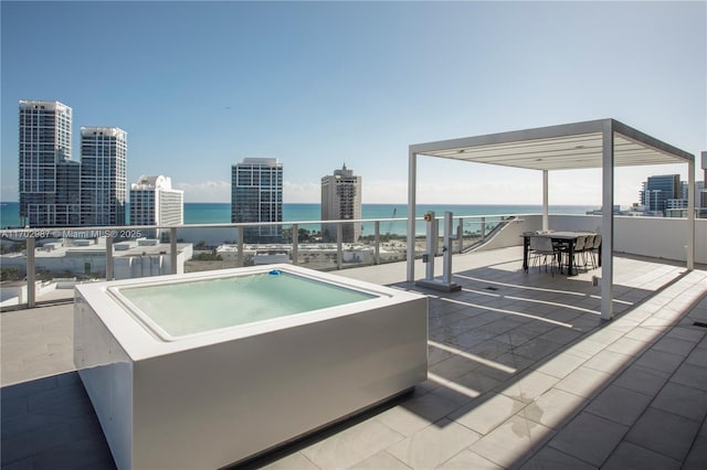 view of swimming pool featuring a jacuzzi, a water view, and a patio area