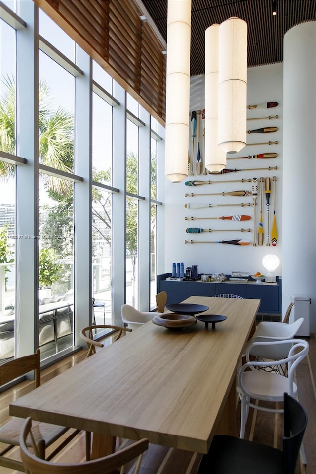 dining room featuring floor to ceiling windows, plenty of natural light, and a towering ceiling