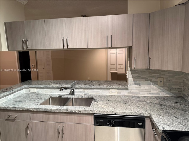 kitchen featuring stainless steel dishwasher, light stone counters, sink, and light brown cabinetry