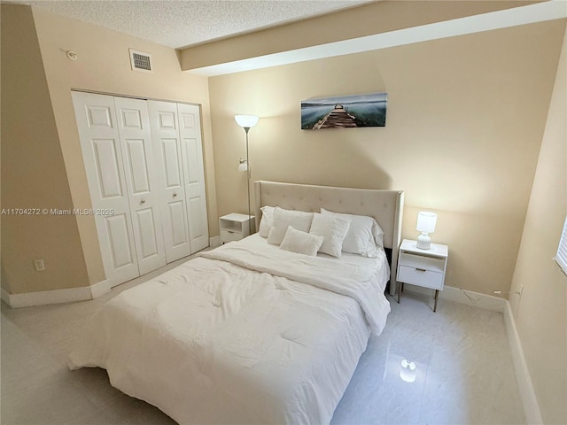 bedroom with a closet, carpet floors, and a textured ceiling