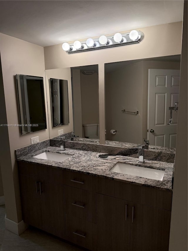 bathroom with tile patterned flooring, vanity, and toilet