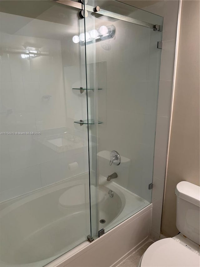 bathroom with combined bath / shower with glass door and toilet