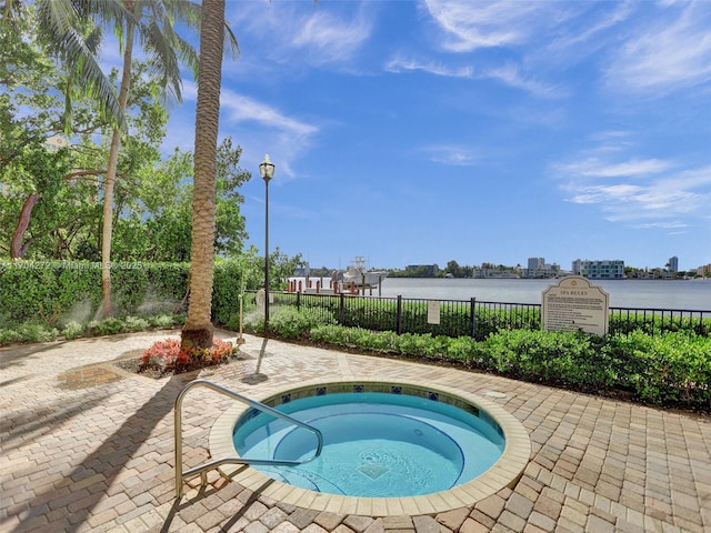 view of swimming pool with a water view and a hot tub