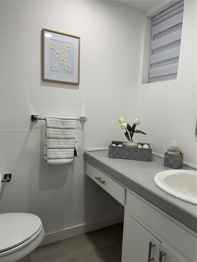 bathroom with vanity, toilet, and wood-type flooring