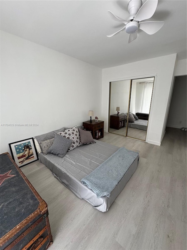 bedroom featuring light hardwood / wood-style flooring, a closet, and ceiling fan