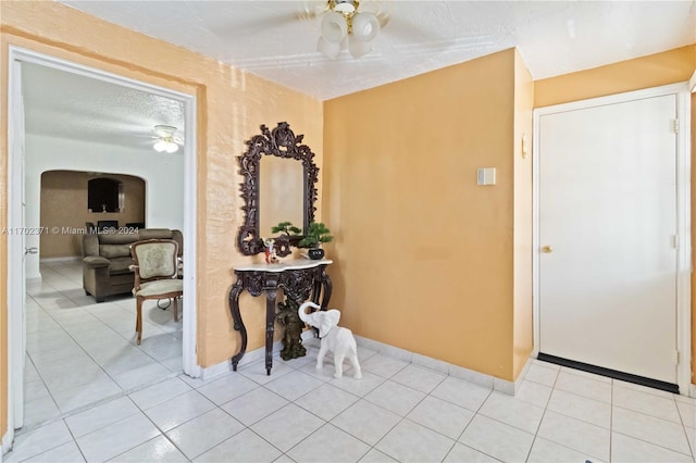 hall with light tile patterned floors and a textured ceiling