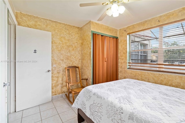 bedroom with light tile patterned floors, a closet, and ceiling fan