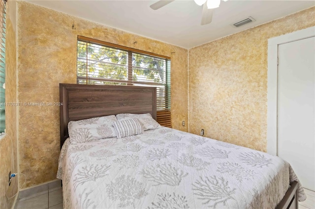 tiled bedroom featuring ceiling fan