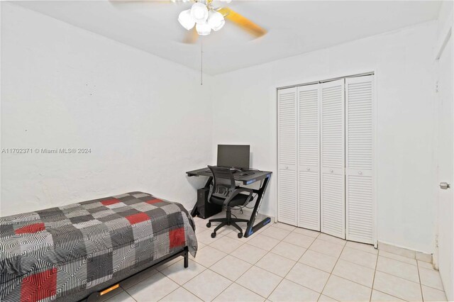 bedroom featuring light tile patterned floors, a closet, and ceiling fan