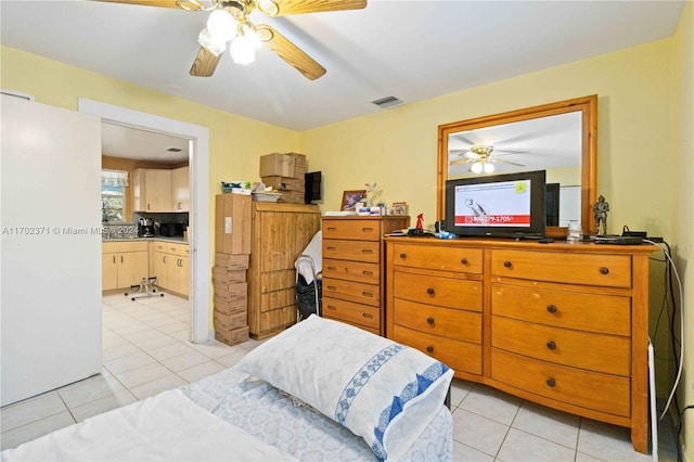 tiled bedroom with ceiling fan and white refrigerator