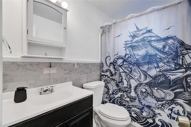 bathroom with vanity, toilet, and tile walls