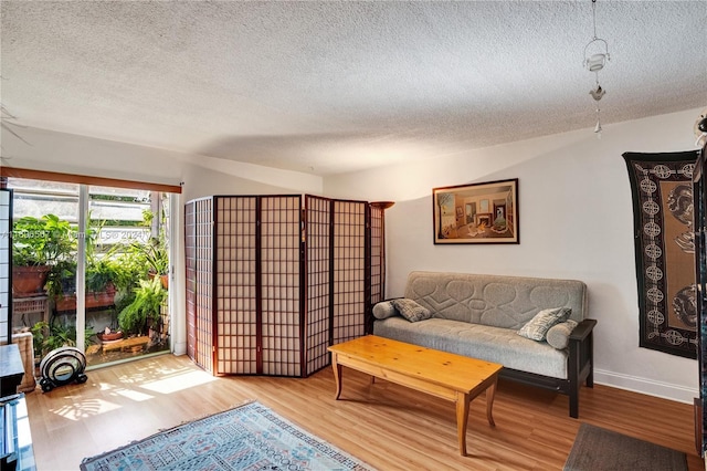 living room with a textured ceiling and light wood-type flooring