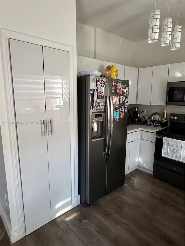 kitchen with appliances with stainless steel finishes, dark hardwood / wood-style flooring, and white cabinetry