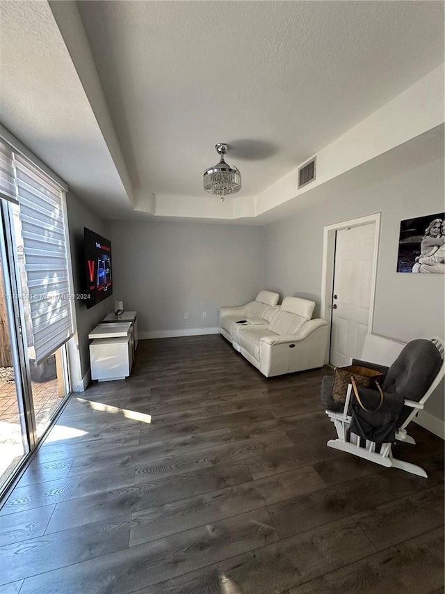 interior space featuring dark hardwood / wood-style flooring, access to outside, and a raised ceiling