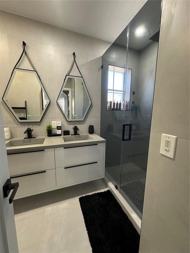 bathroom with tile patterned flooring, vanity, and a shower with door