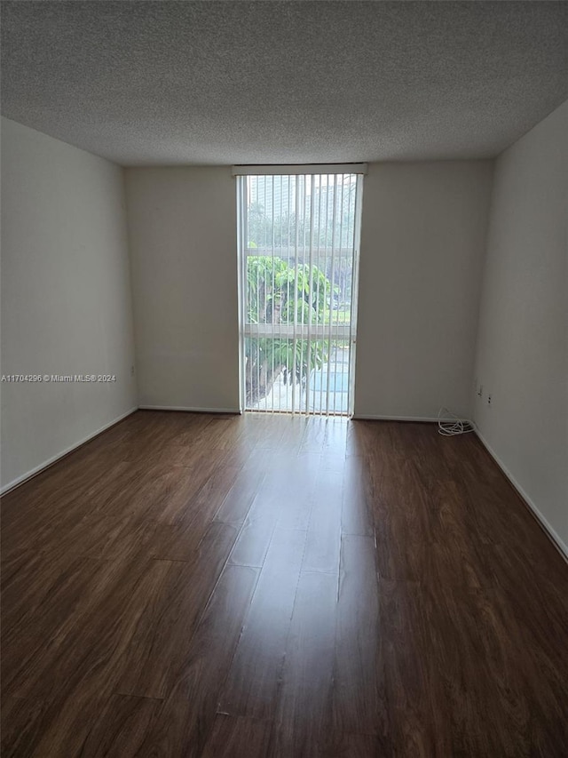 unfurnished room featuring a textured ceiling and dark wood-type flooring