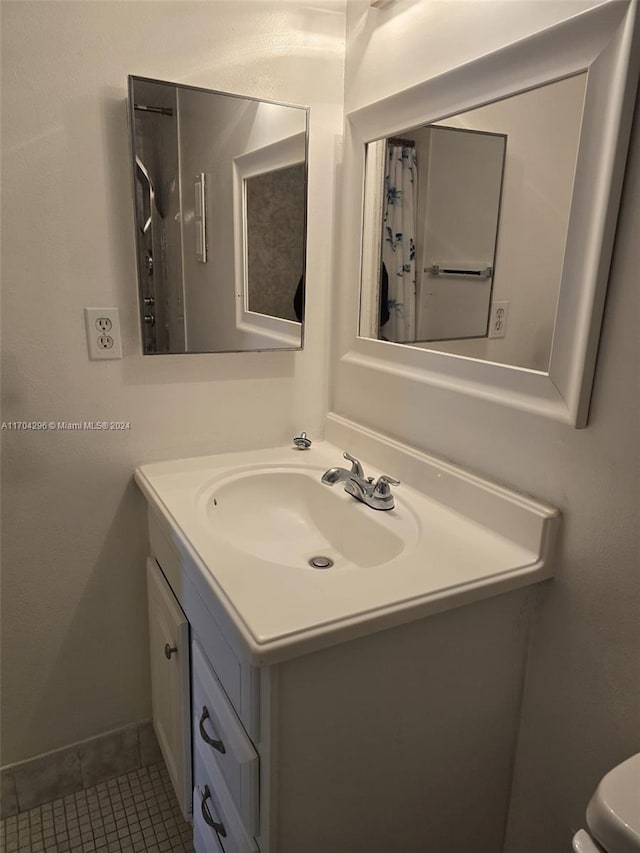 bathroom featuring tile patterned flooring, vanity, and toilet