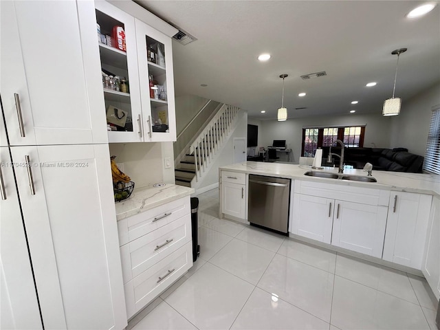 kitchen with dishwasher, white cabinetry, light stone countertops, and sink