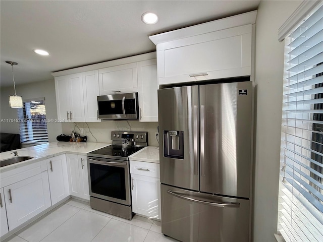 kitchen featuring white cabinetry, a wealth of natural light, hanging light fixtures, and stainless steel appliances