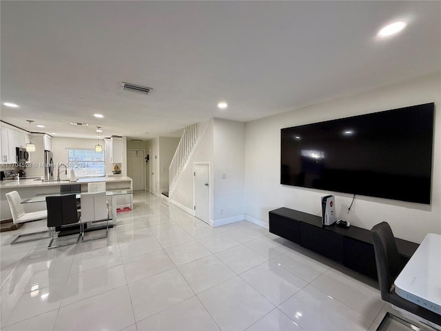 living room featuring light tile patterned floors and sink