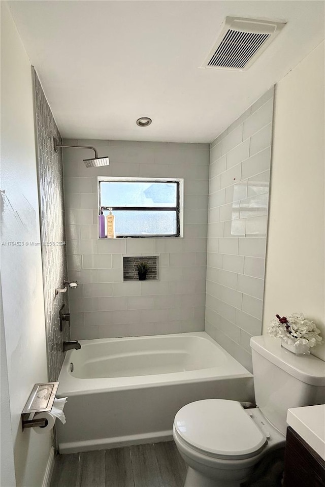 full bathroom featuring tiled shower / bath, toilet, vanity, and hardwood / wood-style flooring