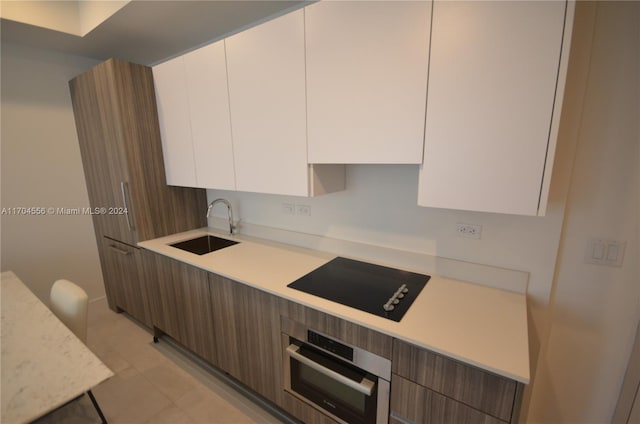 239 SW 9th St Unit 1603, Miami, FL 33130 - kitchen featuring black electric cooktop, modern cabinets, light countertops, and oven