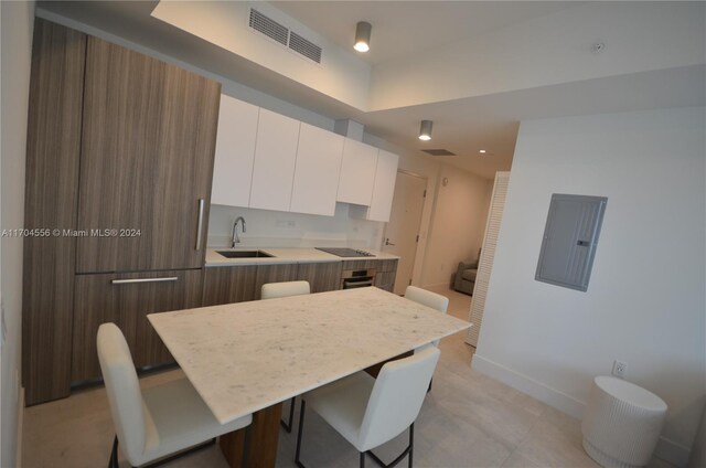 239 SW 9th St Unit 1603, Miami, FL 33130 - kitchen with electric panel, modern cabinets, black electric stovetop, and white cabinets