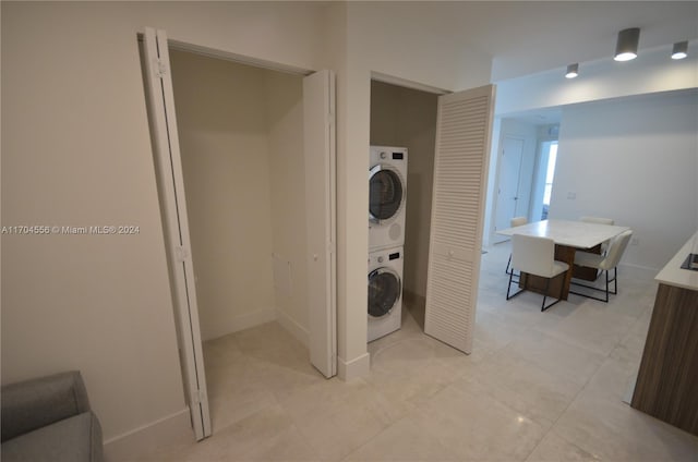 washroom featuring stacked washer and clothes dryer