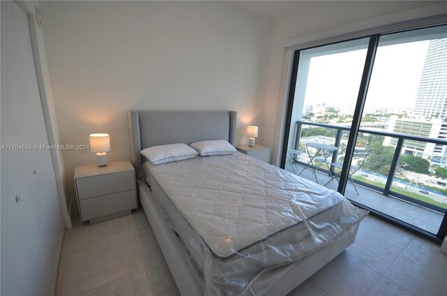 239 SW 9th St Unit 1603, Miami, FL 33130 - bedroom with multiple windows, light tile patterned floors, and a city view