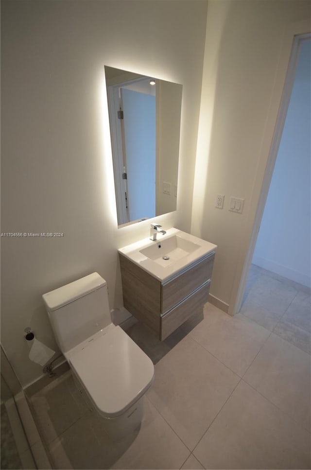 bathroom with tile patterned flooring, vanity, and toilet