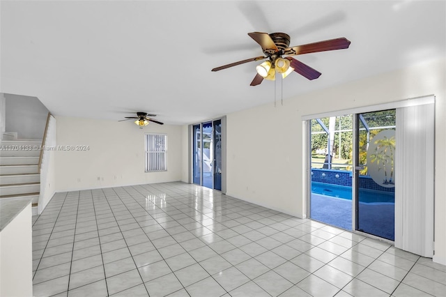 tiled empty room featuring ceiling fan