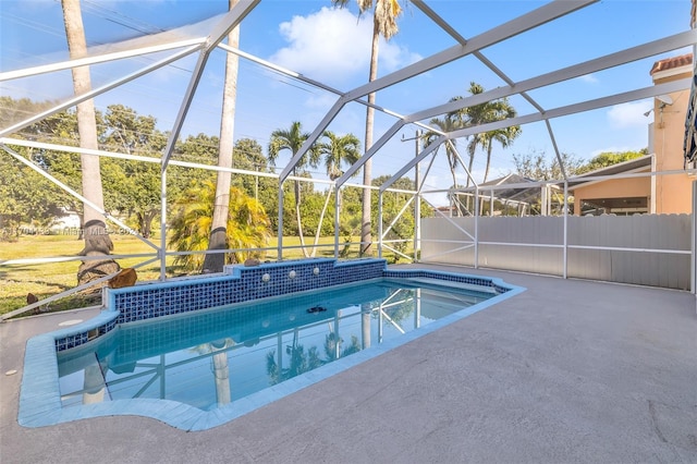 view of swimming pool featuring glass enclosure and a patio