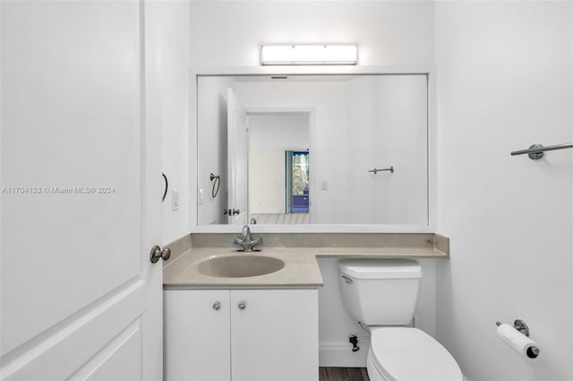 bathroom with vanity, wood-type flooring, and toilet