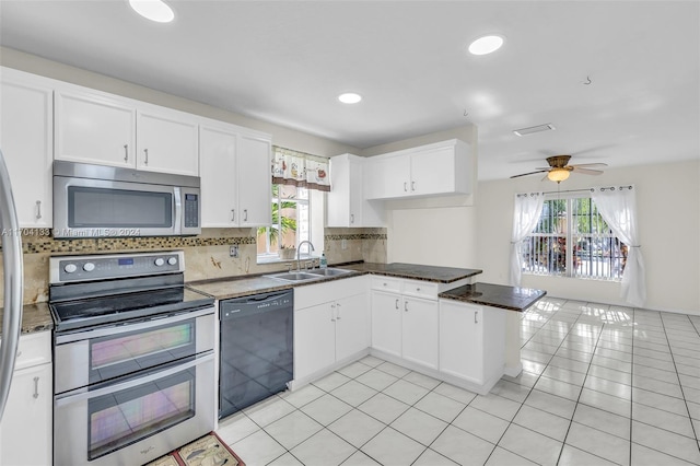 kitchen featuring kitchen peninsula, appliances with stainless steel finishes, ceiling fan, sink, and white cabinets