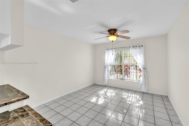 spare room featuring light tile patterned floors and ceiling fan