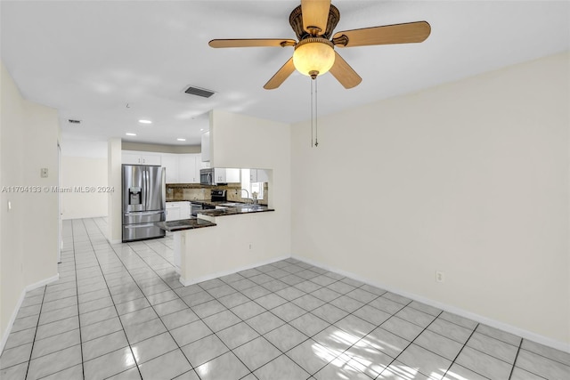 unfurnished living room featuring ceiling fan, light tile patterned floors, and sink