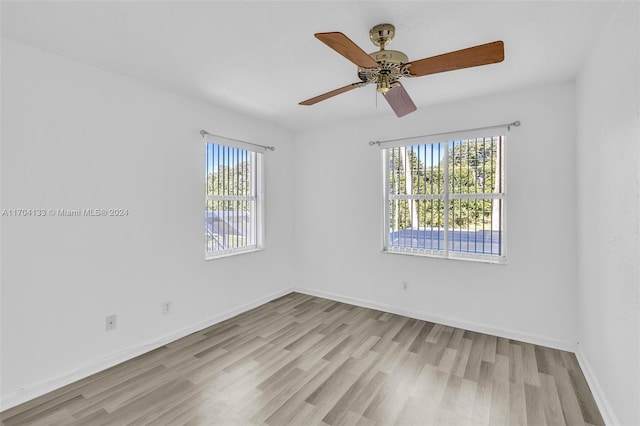 empty room featuring ceiling fan, plenty of natural light, and light hardwood / wood-style floors