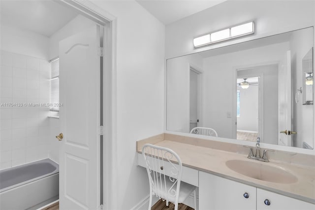 bathroom with tiled shower / bath, vanity, hardwood / wood-style flooring, and ceiling fan