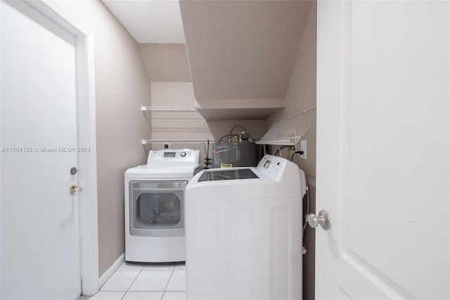 clothes washing area with light tile patterned flooring, washing machine and dryer, and electric water heater